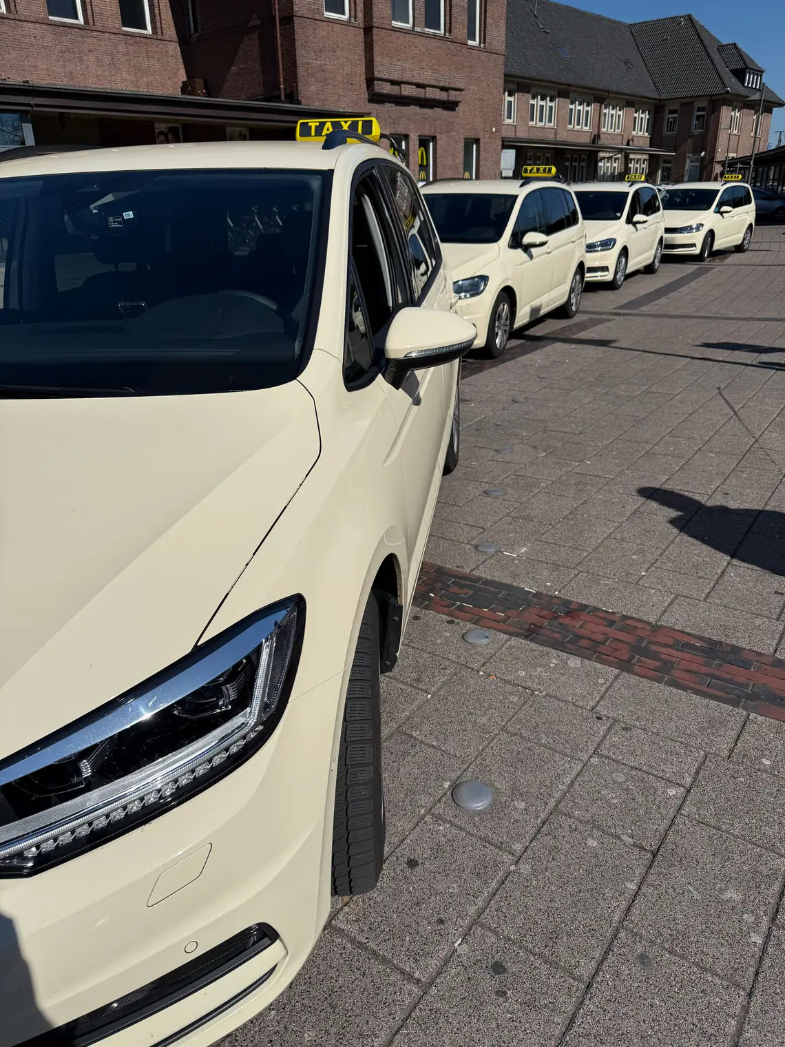 Die TaxiGo-Flotte mit mehreren hellen Taxis am Hauptbahnhof Oldenburg